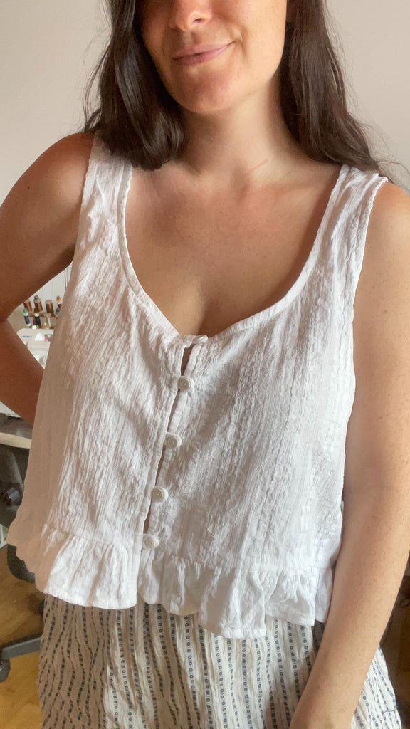 Loïse wearing the hacked Violette top, a white crinkle cotton top with a scoop neckline, rouleau button loop placket and ruffle hem